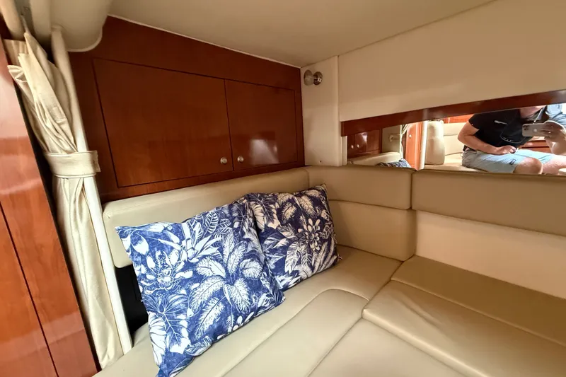 Slide: The Image of Interior of 2006 Sea Ray Sundancer 320 with beige seating and decorative blue pillows. - 45