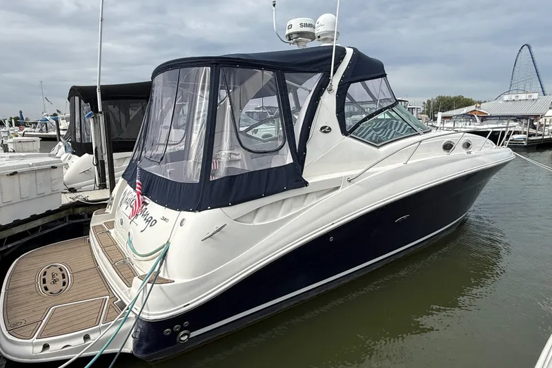 The Image of 2006 Sea Ray Sundancer 320 docked, featuring a sleek design and enclosed cockpit. - 0