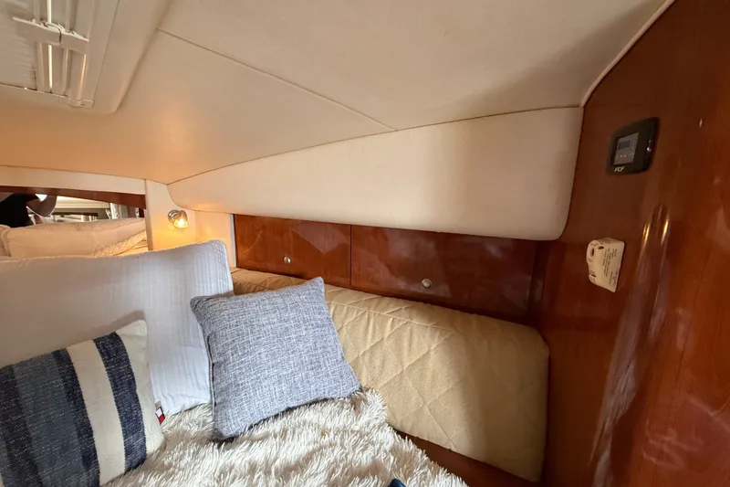 Slide: The Image of 2006 Sea Ray Sundancer 320 cabin interior with cozy bedding and wooden accents. - 39