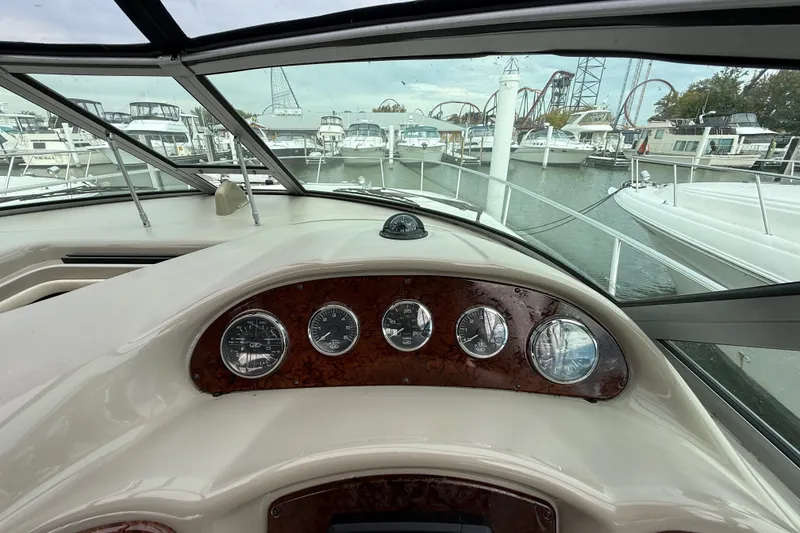 Slide: The Image of Cockpit view of 2006 Sea Ray Sundancer 320, docked with marina and boats in background. - 22