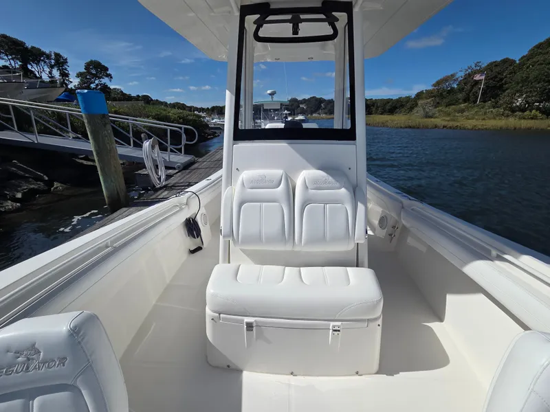 Slide: The Image of The image shows the cockpit of a 2020 Regulator 25 boat with white seating and clear skies. - 15