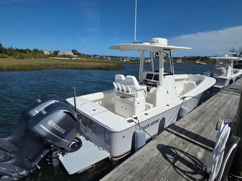 Slide: The Image of A 2020 Regulator 25 boat docked. It features twin Yamaha engines. - 5