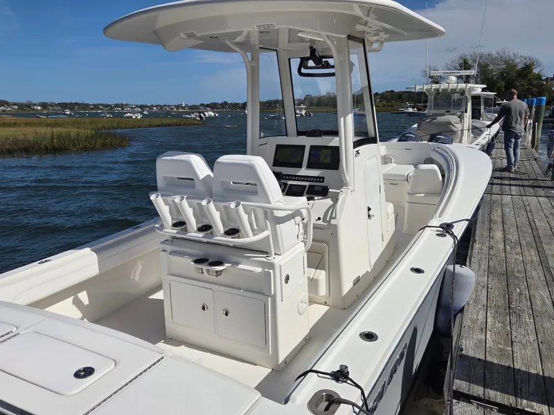 Slide: The Image of A 2020 Regulator 25 boat docked. It features a modern cockpit and comfortable seating. - 6