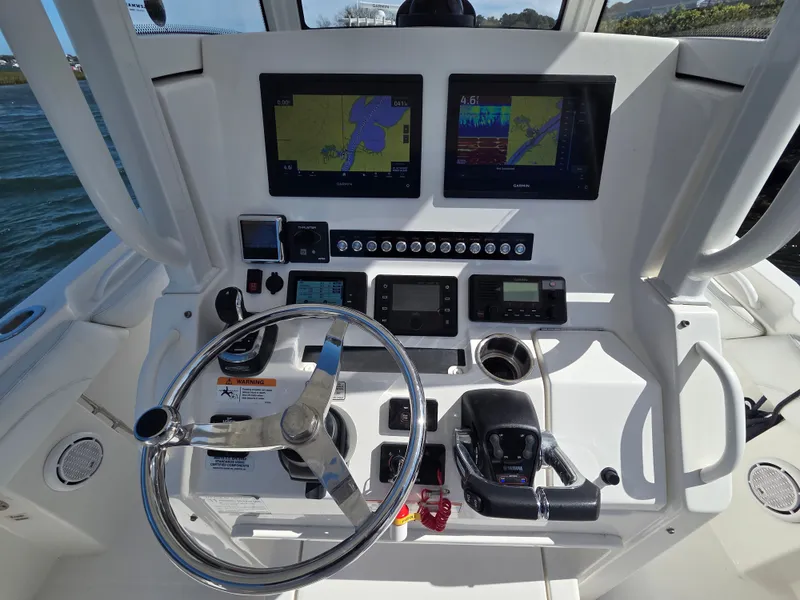 Slide: The Image of The cockpit of a 2020 Regulator 25 with modern navigation screens and a stainless steel steering wheel. - 9