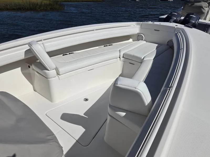 Slide: The Image of The image shows the bow area of a 2020 Regulator 25 boat with white cushioned seating. - 17