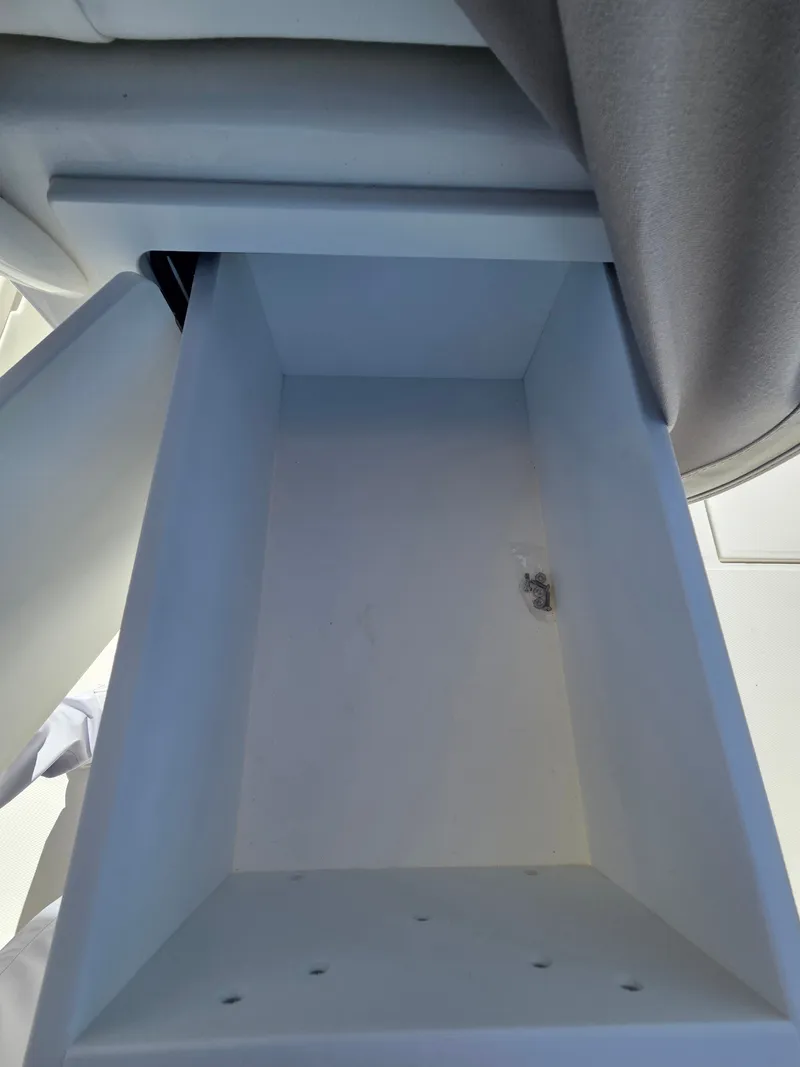 Slide: The Image of An empty, rectangular storage compartment on a boat, with a small metal bracket on the side. - 20