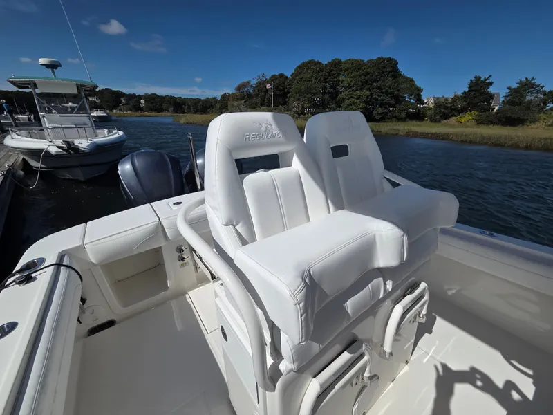 Slide: The Image of The image shows the cockpit of a 2020 Regulator 25 boat with white seating. - 14