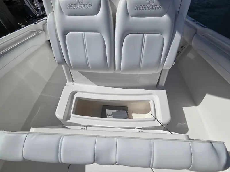 Slide: The Image of The image shows the seating area of a 2020 Regulator 25 boat with white upholstery. - 16