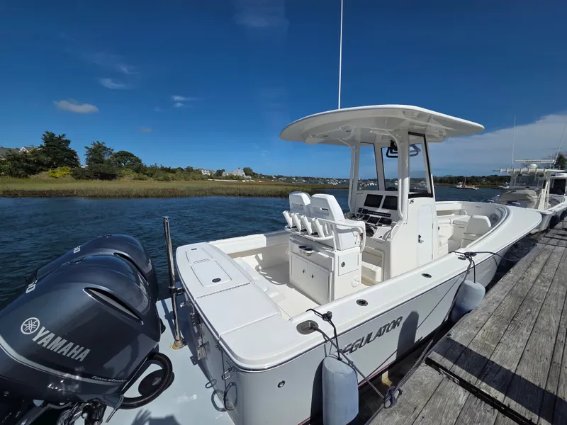 Slide: The Image of A 2020 Regulator 25 boat docked. It features twin Yamaha outboard engines. - 4