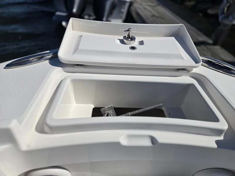Slide: The Image of An open storage compartment on a 2020 Regulator 25 boat, with a small item inside. - 19