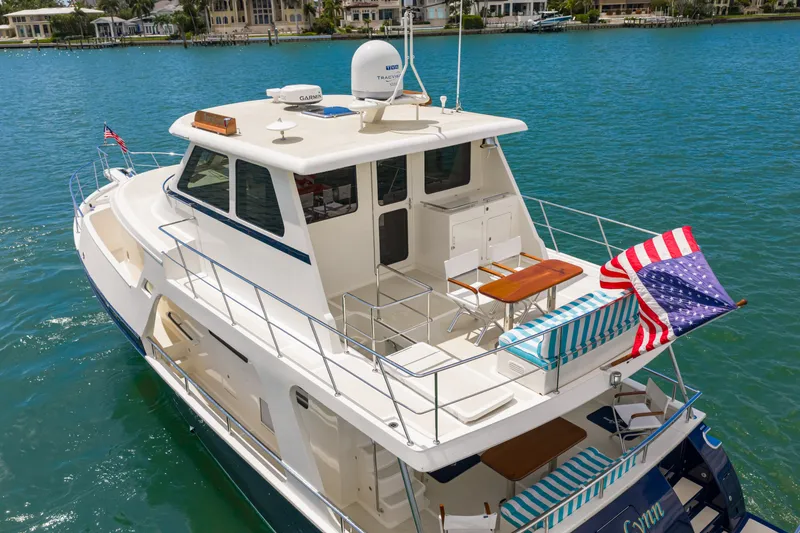 Slide: The Image of 2017 Marlow Explorer 49E yacht on blue water, featuring spacious deck and American flag. - 25