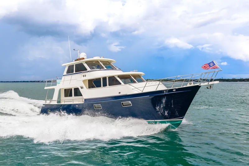Slide: The Image of 2017 Marlow Explorer 49E yacht cruising on open water under a cloudy sky. - 2