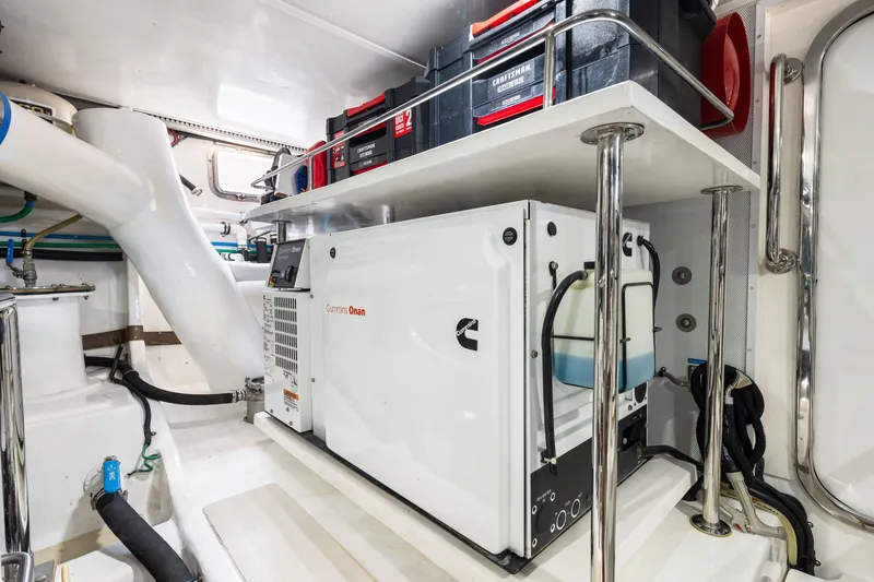 Slide: The Image of Engine room of 2017 Marlow Explorer 49E with Cummins Onan generator and tool storage. - 52