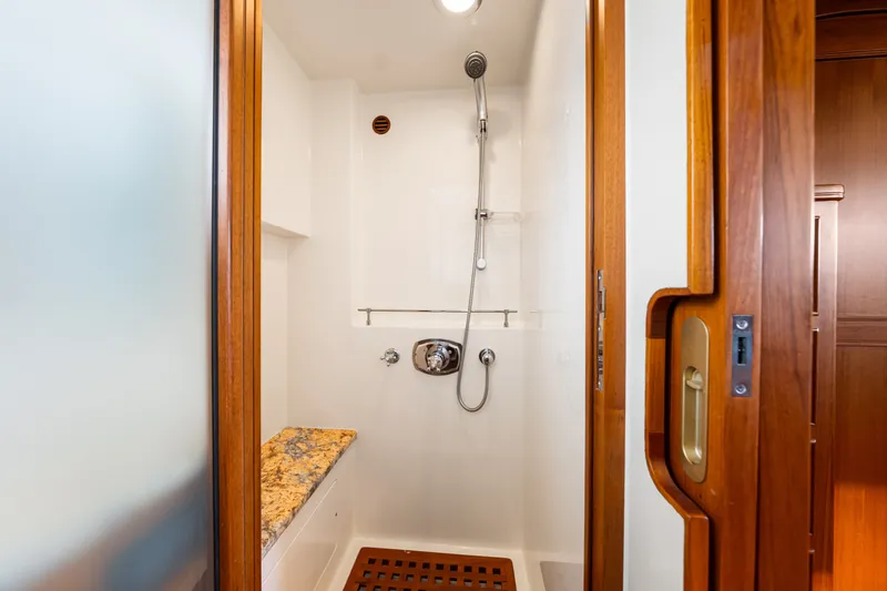 Slide: The Image of Shower area in 2017 Marlow Explorer 49E yacht with wooden accents and granite bench. - 46