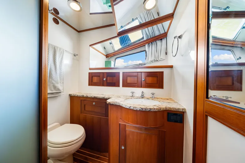 Slide: The Image of Luxurious bathroom in 2017 Marlow Explorer 49E yacht with wood cabinetry and marble countertop. - 49