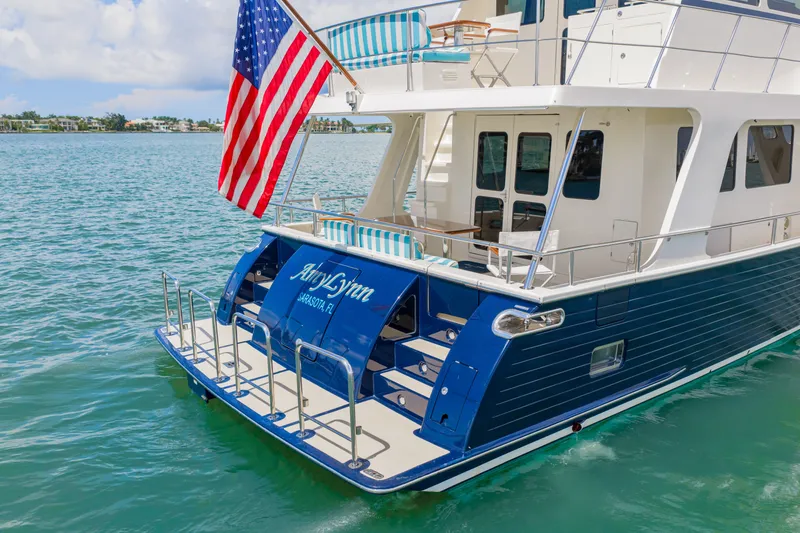 Slide: The Image of 2017 Marlow Explorer 49E yacht with American flag, docked in serene waters. - 24