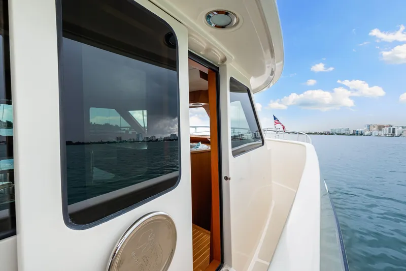 Slide: The Image of 2017 Marlow Explorer 49E yacht on calm waters with cityscape in background. - 12