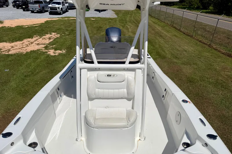 Slide: The Image of 2017 Sea Hunt BX25BR boat interior with seating and console, parked on grass. - 5