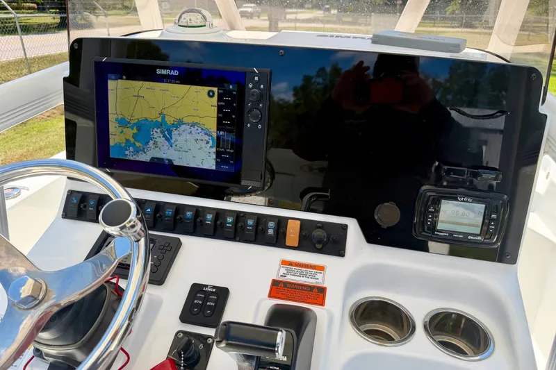 Slide: The Image of 2017 Sea Hunt BX25BR boat dashboard with Simrad navigation display and steering wheel. - 12