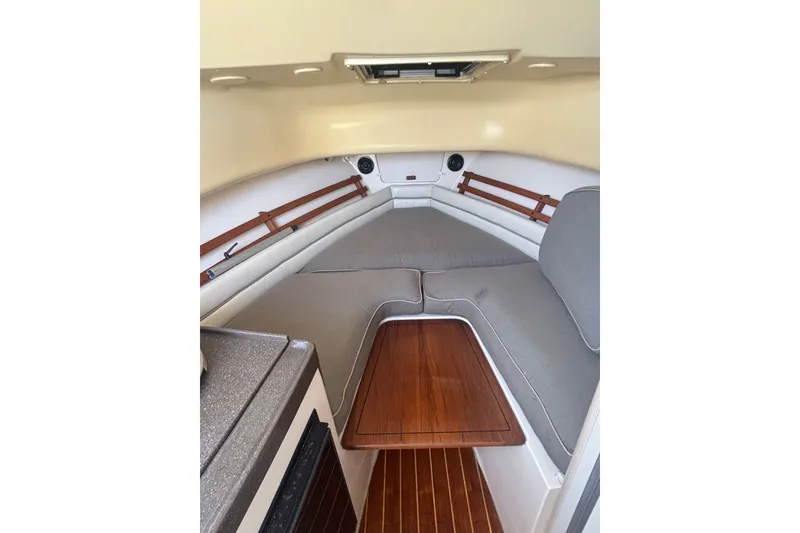 Slide: The Image of 2005 Grady White 282 Sailfish cabin interior with cushioned seating and wooden accents. - 28