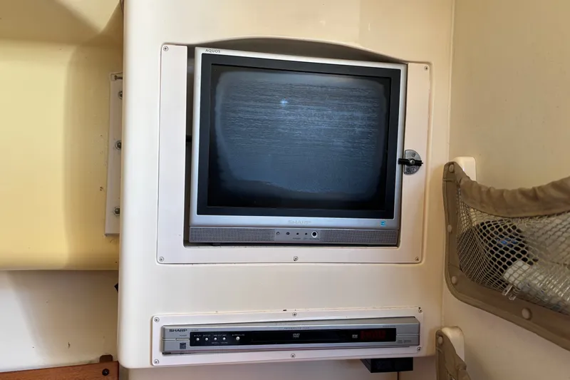 Slide: The Image of Built-in Sharp TV and DVD player on 2005 Grady White 282 Sailfish boat interior. - 16