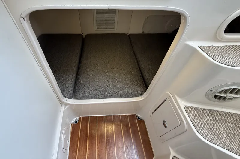 Slide: The Image of 2005 Grady White 282 Sailfish cabin interior with cushioned seating and wooden flooring. - 11