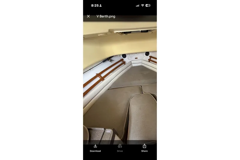Slide: The Image of 2005 Grady White 282 Sailfish V-berth interior with beige cushions and wood accents. - 13