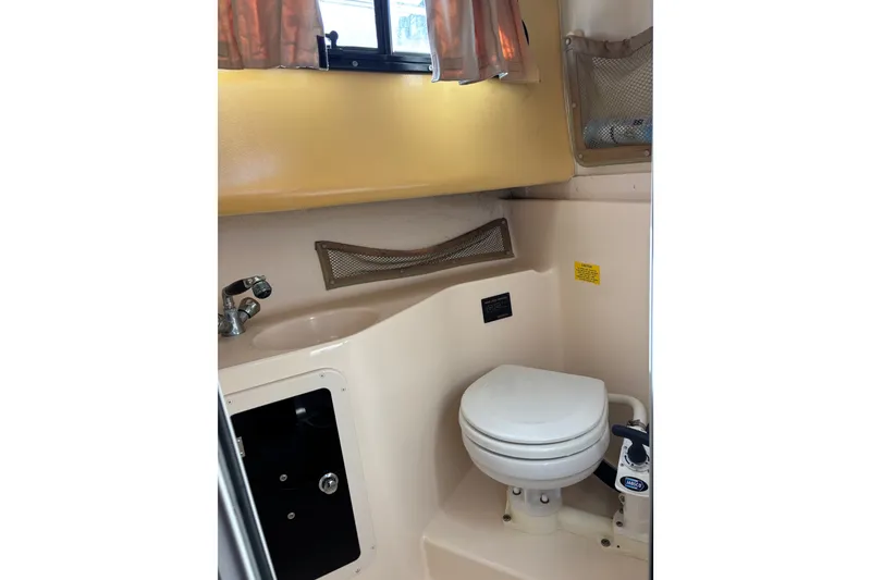 Slide: The Image of 2005 Grady White 282 Sailfish boat bathroom with sink, toilet, and storage compartments. - 17