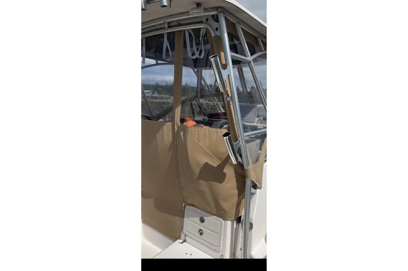 Slide: The Image of 2005 Grady White 282 Sailfish boat with tan canvas enclosure and rod holders. - 24