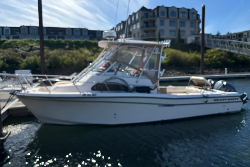 Slide: The Image of 2005 Grady White 282 Sailfish boat docked at marina with waterfront buildings. - 25