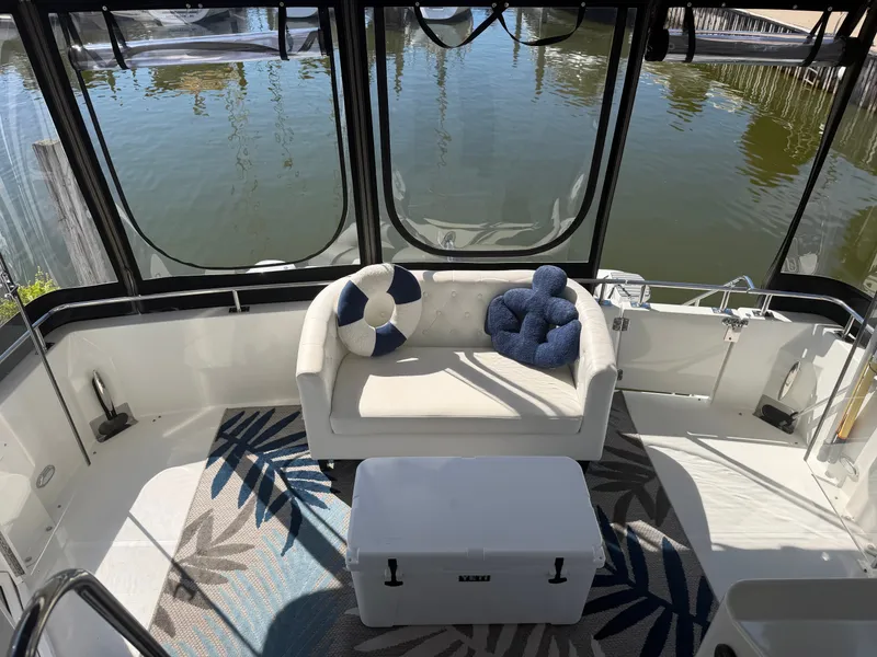 Slide: The Image of The 2000 Carver 396 Motor Yacht features a stylish aft deck with a sofa and decorative cushions. - 25