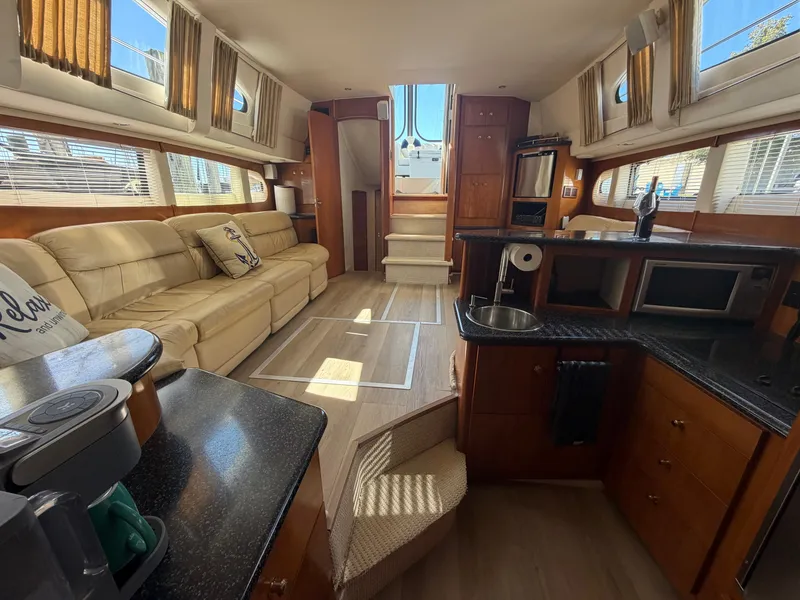 Slide: The Image of Interior of a 2000 Carver 396 Motor Yacht featuring a cozy living area and kitchen. - 42