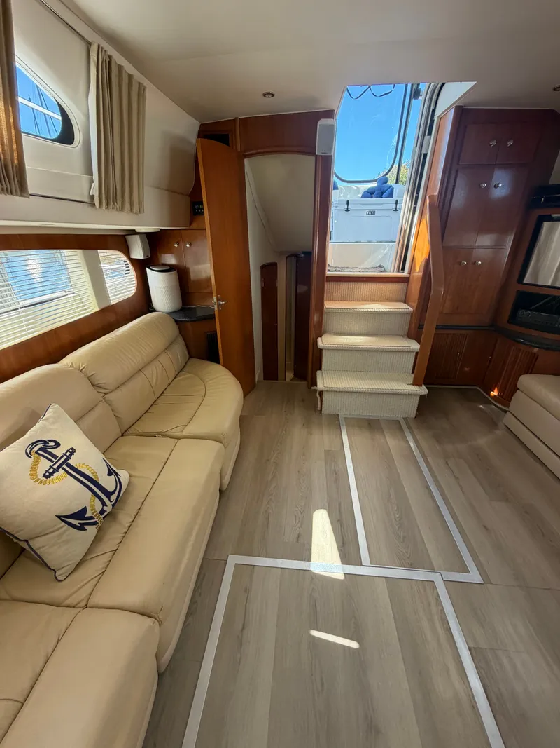 Slide: The Image of Interior of a 2000 Carver 396 Motor Yacht with beige sofa and wooden flooring. - 38