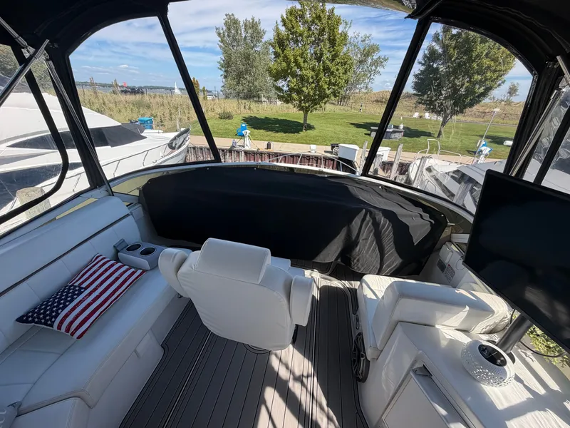 Slide: The Image of The image shows the cockpit of a 2000 Carver 396 Motor Yacht with white seating and an American flag pillow. - 17