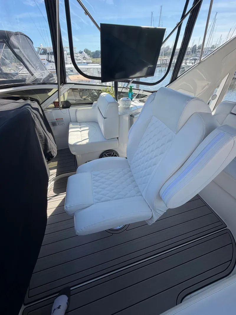Slide: The Image of The 2000 Carver 396 Motor Yacht features luxurious white seating in the cockpit area overlooking the marina. - 20