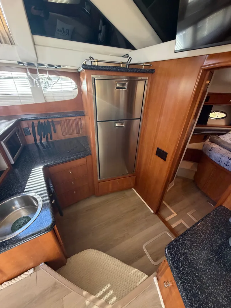 Slide: The Image of Interior of a 2000 Carver 396 Motor Yacht featuring a kitchen and sleeping area. - 44