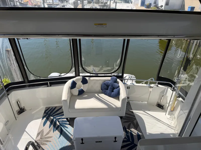 Slide: The Image of The image shows the cockpit of a 2000 Carver 396 Motor Yacht with a sofa and cushions. - 23