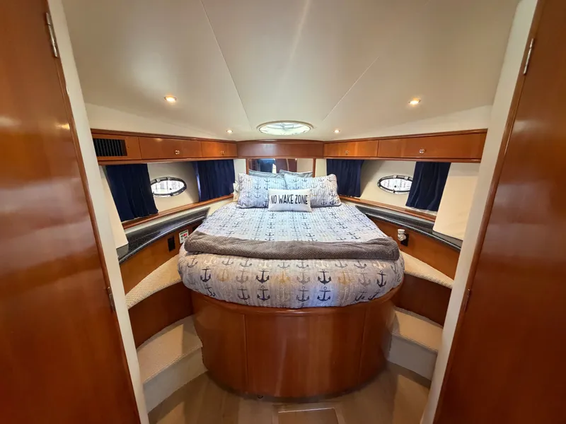 Slide: The Image of The cabin of the 2000 Carver 396 Motor Yacht features a cozy bed with nautical-themed bedding. - 47