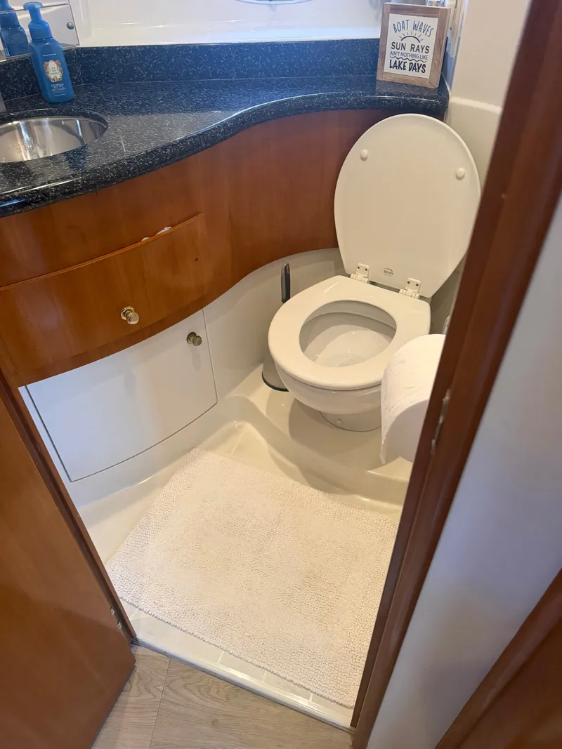 Slide: The Image of The image shows a yacht bathroom with a toilet, sink, and wooden cabinetry. - 49