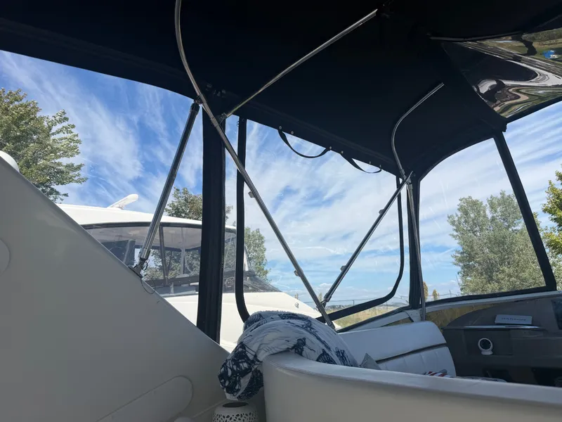 Slide: The Image of Interior view of a 2000 Carver 396 Motor Yacht with a black canopy and blue sky. - 33