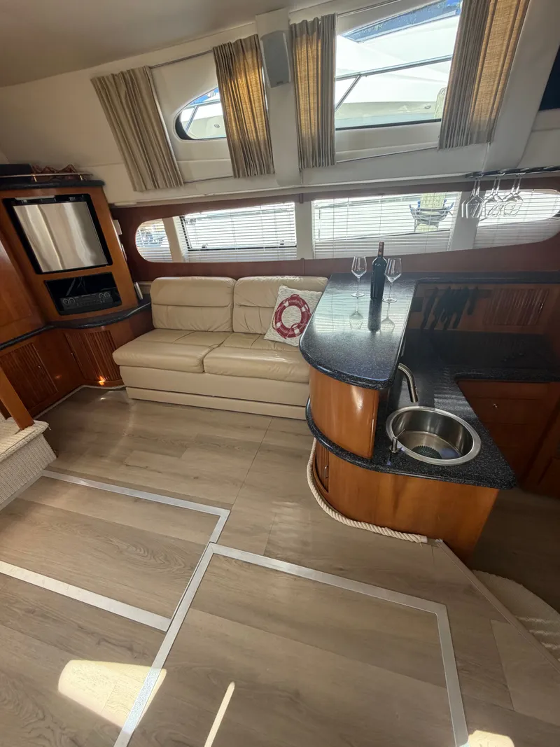 Slide: The Image of Interior of a 2000 Carver 396 Motor Yacht with sofa, bar, and windows. - 40