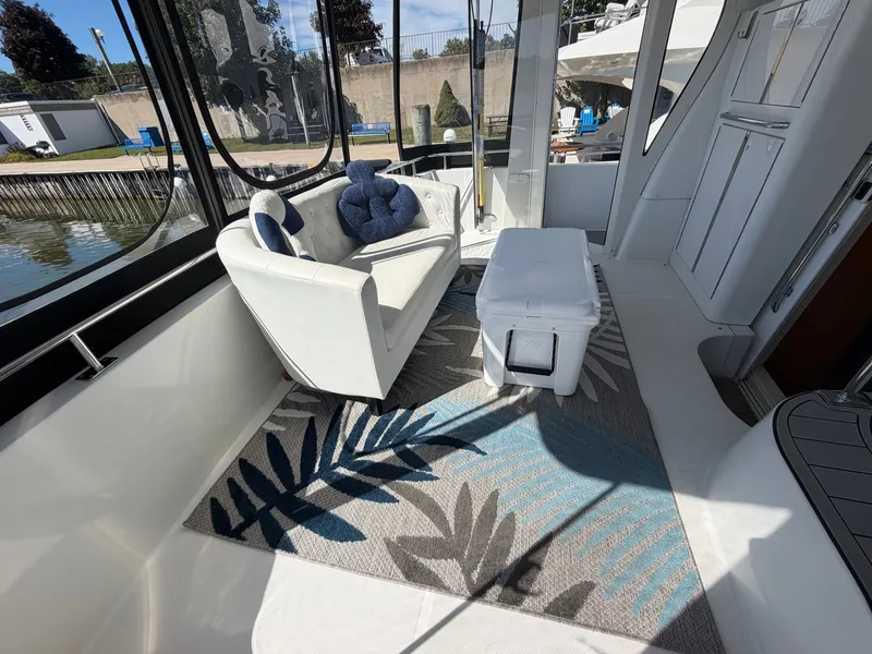 Slide: The Image of The interior of a 2000 Carver 396 Motor Yacht features an elegant sofa and a rug. - 24