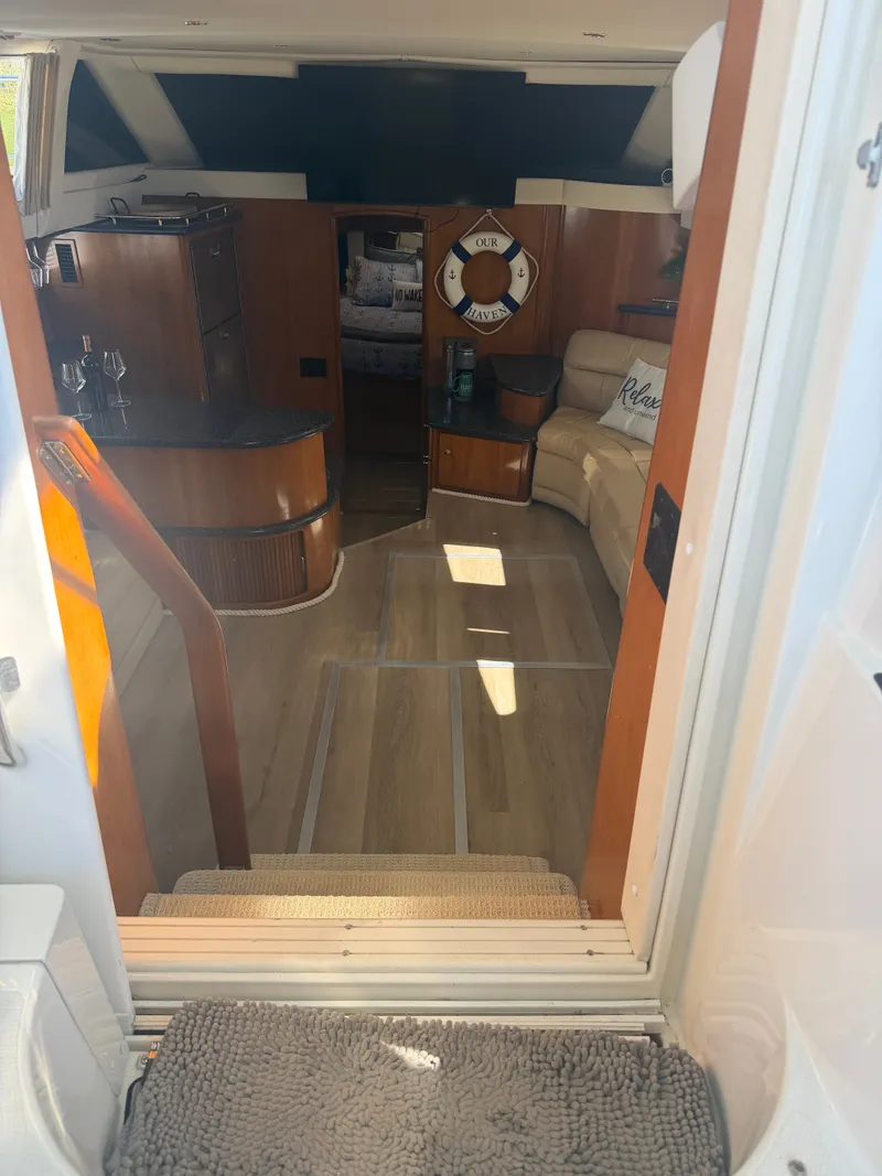 Slide: The Image of The interior of a 2000 Carver 396 Motor Yacht features a cozy living area with wooden furnishings. - 34