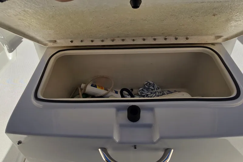 Slide: The Image of Open storage compartment on 2023 Bayliner Trophy T24CC boat with ropes and supplies. - 26