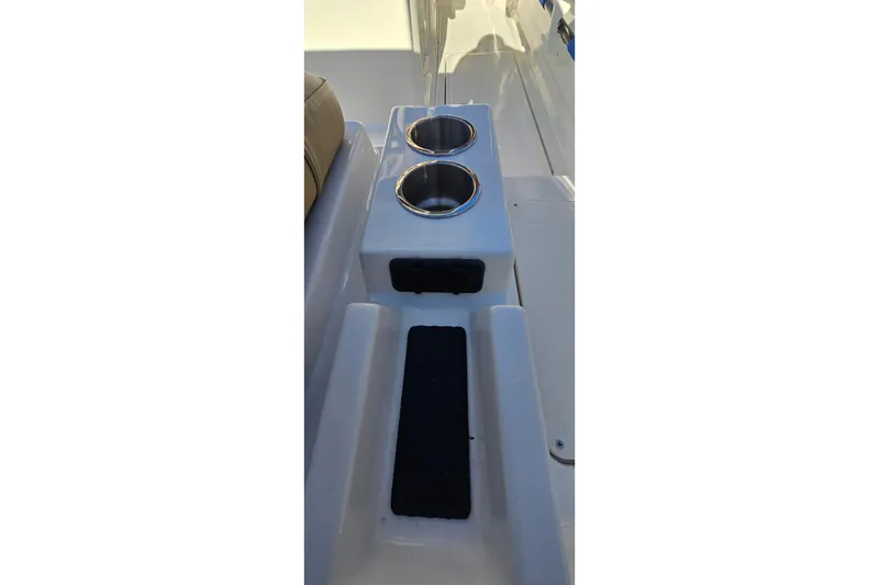 Slide: The Image of 2023 Bayliner Trophy T24CC boat interior with dual cup holders and seating area. - 21