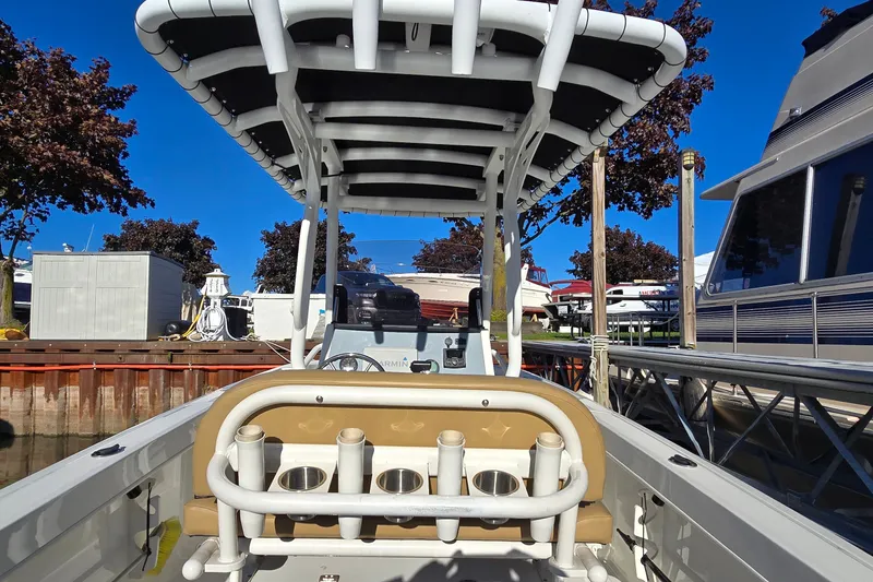 Slide: The Image of 2023 Bayliner Trophy T24CC boat interior with rod holders and canopy at dock. - 14