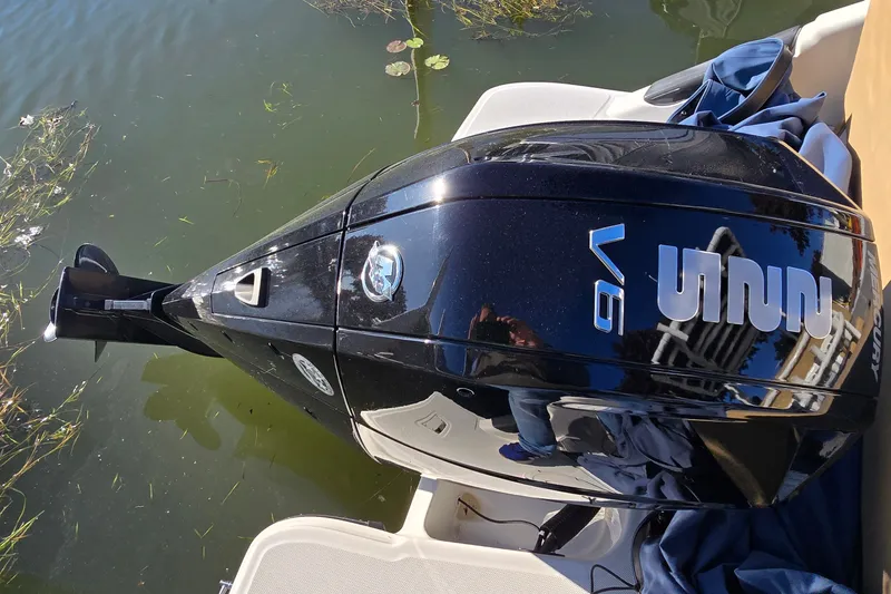 Slide: The Image of Outboard motor on 2023 Bayliner Trophy T24CC boat, docked on calm water. - 19