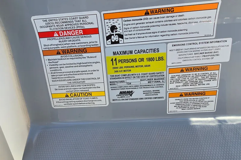 Slide: The Image of Safety and capacity labels on 2023 Bayliner Trophy T24CC boat, detailing warnings and maximum load. - 15
