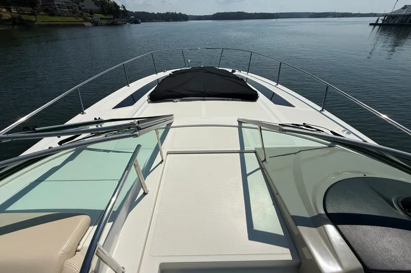 Slide: The Image of 2013 Sea Ray Sundancer 350 yacht deck overlooking calm waters and distant shoreline. - 17