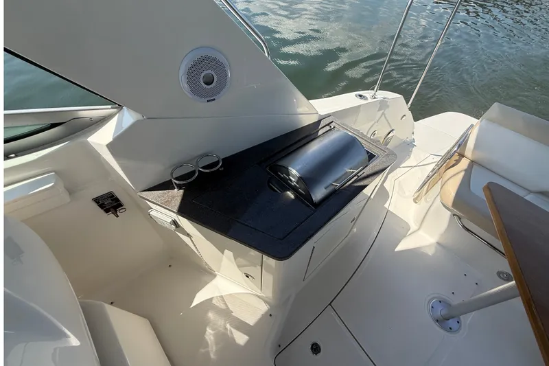 Slide: The Image of 2013 Sea Ray Sundancer 350 boat interior with grill and seating area by the water. - 33